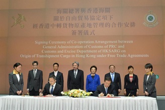 The Financial Secretary, Mr John C Tsang (back row, third left); the Deputy Director of the Liaison Office of the Central People's Government in the Hong Kong Special Administrative Region, Ms Qiu Hong (back row, third right); the Acting Secretary for Commerce and Economic Development, Mr Godfrey Leung (back row, second left); the Permanent Secretary for Commerce and Economic Development (Commerce, Industry and Tourism), Mr Philip Yung (back row, first left); the Director General of the General Office of the General Administration of Customs, Mr Zhang Guangzhi (back row, second right); and the Deputy Director General of the Department of Duty Collection of the General Administration of Customs, Ms Jiang Feng (back row, first right), witness the signing of the Co-operation Arrangement on Origin of Transhipment Cargo in Hong Kong under Free Trade Agreements by the Commissioner of Customs a