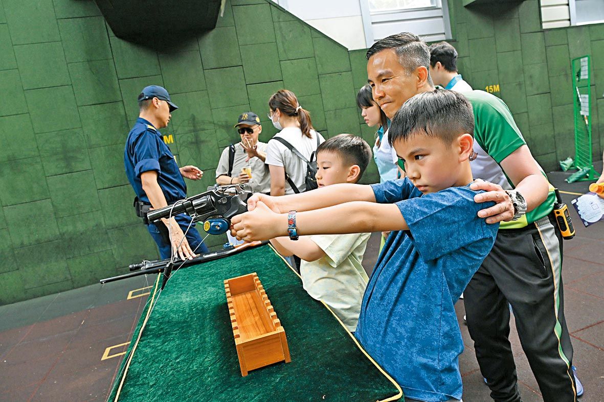 入場人士參觀槍械及裝備展示。