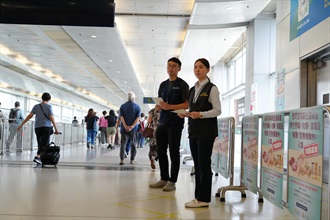 Officers of Hong Kong Customs and the Centre for Food Safety of the Food and Environmental Hygiene Department distribute leaflets at the Lok Ma Chau Spur Line Control Point to remind outgoing travellers not to import regulated food illegally from the Mainland or overseas.